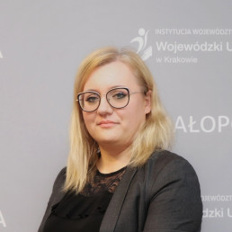 blondynka w okularach w grafitowym żakiecie i koronkowym czarnym topie