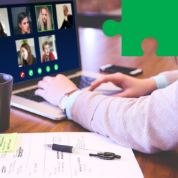 Kobiece ręce leżą na klawiaturze laptopa. Na ekranie urządzenia widoczni są uczestnicy spotkania online.