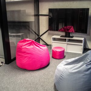 Widok na antresolę z telewizorem i dwiema pufami
