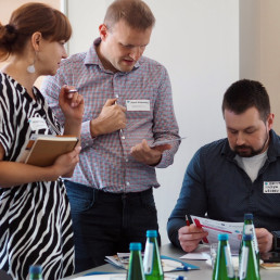 Kobieta i dwaj mężczyźni rozmawiają ze sobą.