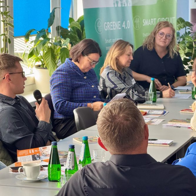 Grupa kobiet i mężczyzn siedzi przy stole i rozmawia ze sobą.