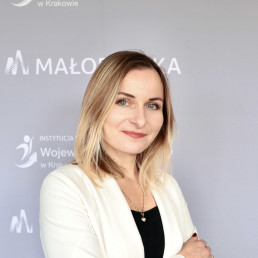 blondynka z prostymi włosami do ramion w czarnym topie i kremowej marynarce