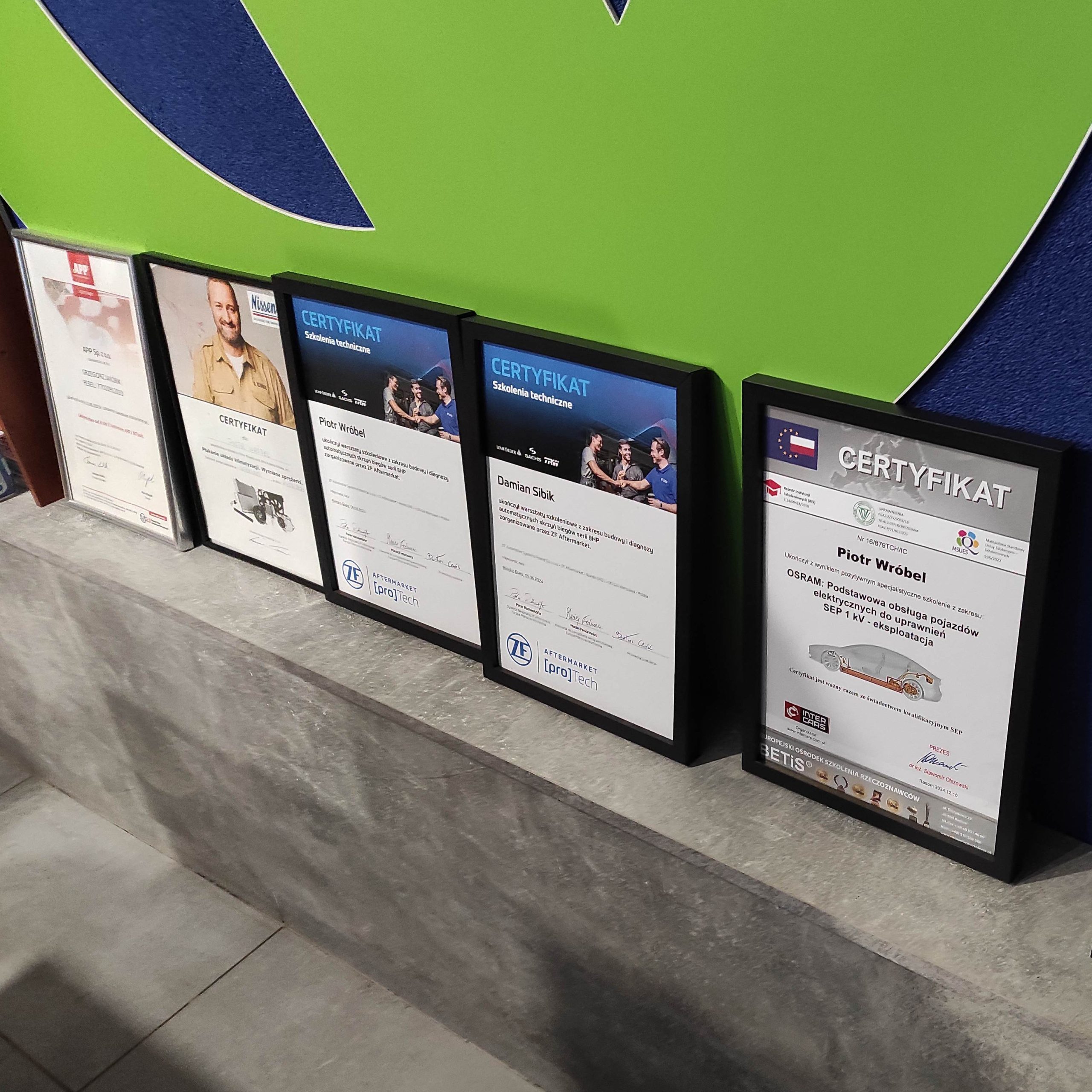 Zbliżenie na certyfikaty, dokumentujące zdobycie kompetencji przez pracowników firmy Spec Car.