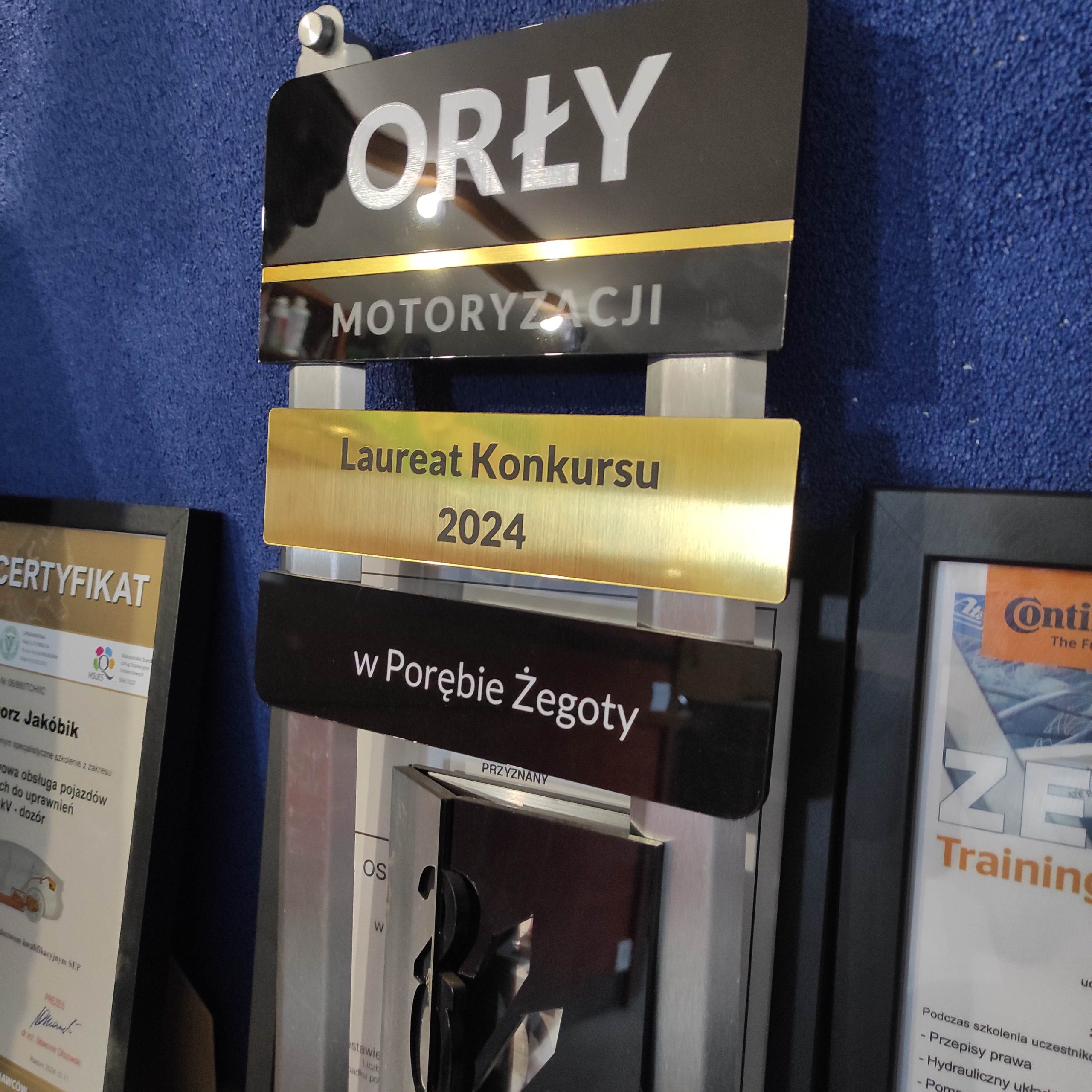 Zbliżenie na statuetkę z napisem: Orły motoryzacji, laureat konkursu 2024 w Porębie Żegoty.