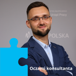 Zbliżenie na młodego mężczyznę w okularach, niebieskiej koszuli i granatowej marynarce. Na dole strony napis: 